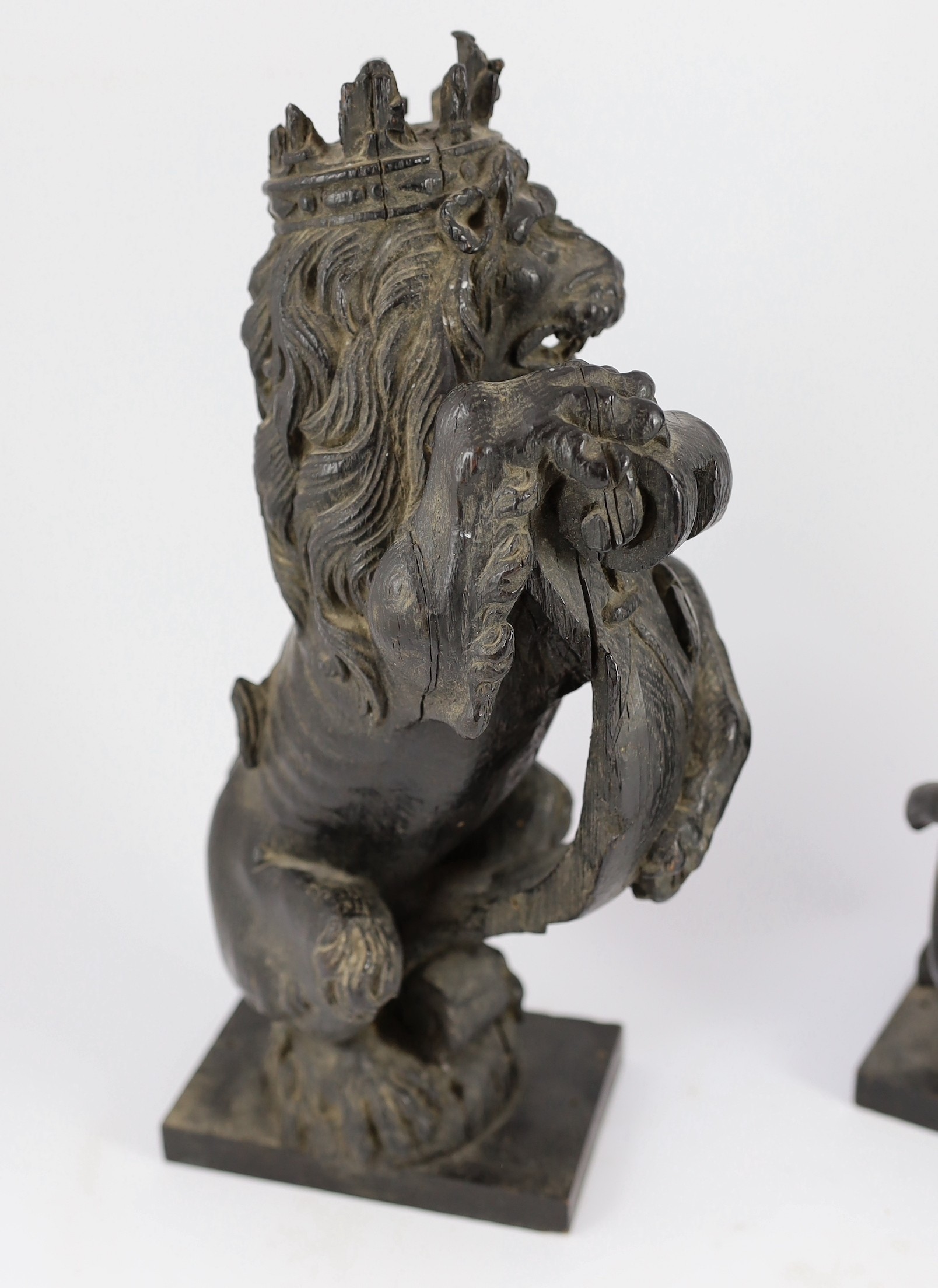 A pair of 18th century carved and ebonised oak heraldic beasts, lion and unicorn, 42cm high